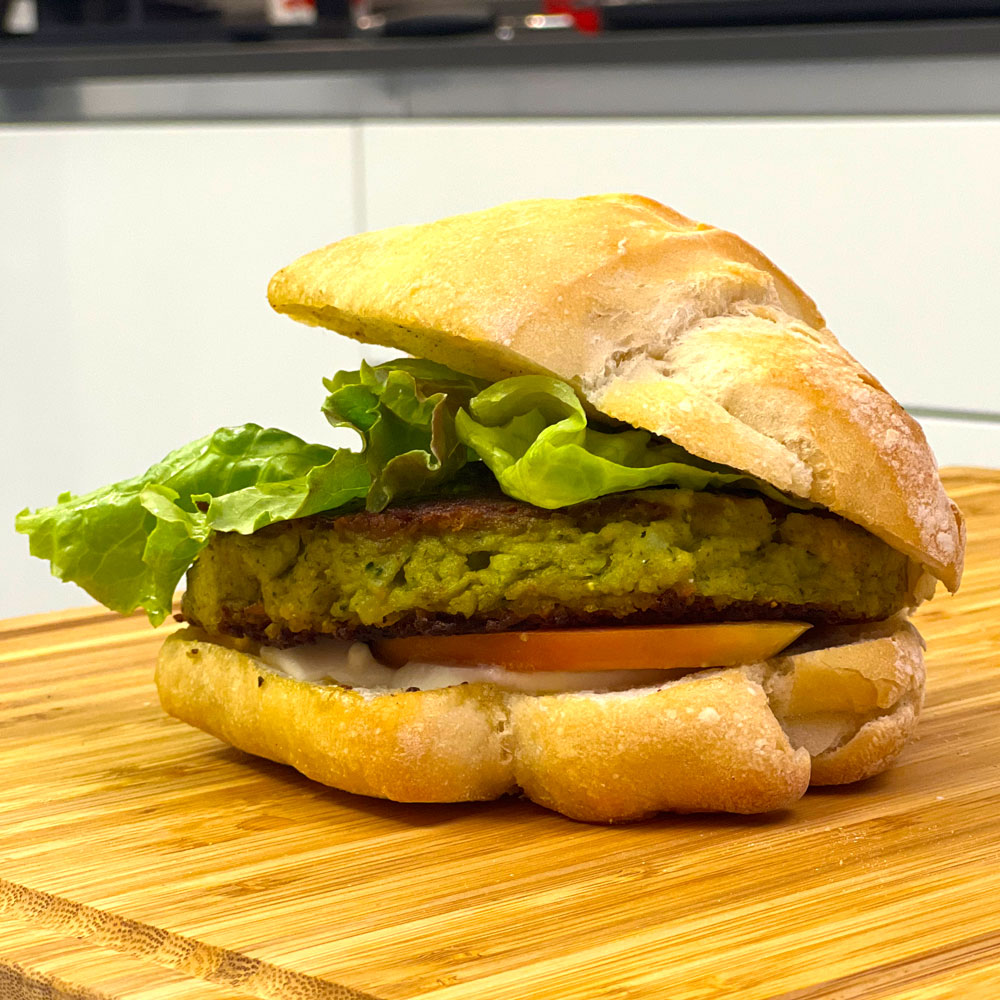 Panino con hamburger di broccolo, insalata e pomodoro