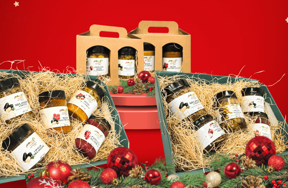 Composizione natalizia con quattro cesti di natale, due piccoli e due grandi contenenti barattoli con verdure sott'olio, passate e sughi