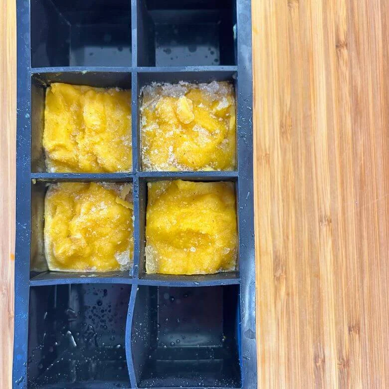stampo per ghiaccio con dado di zucca su tagliere di legno